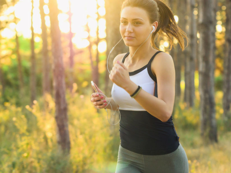 sportski obucena djevojka trci u sumi, tjelesna aktivnost