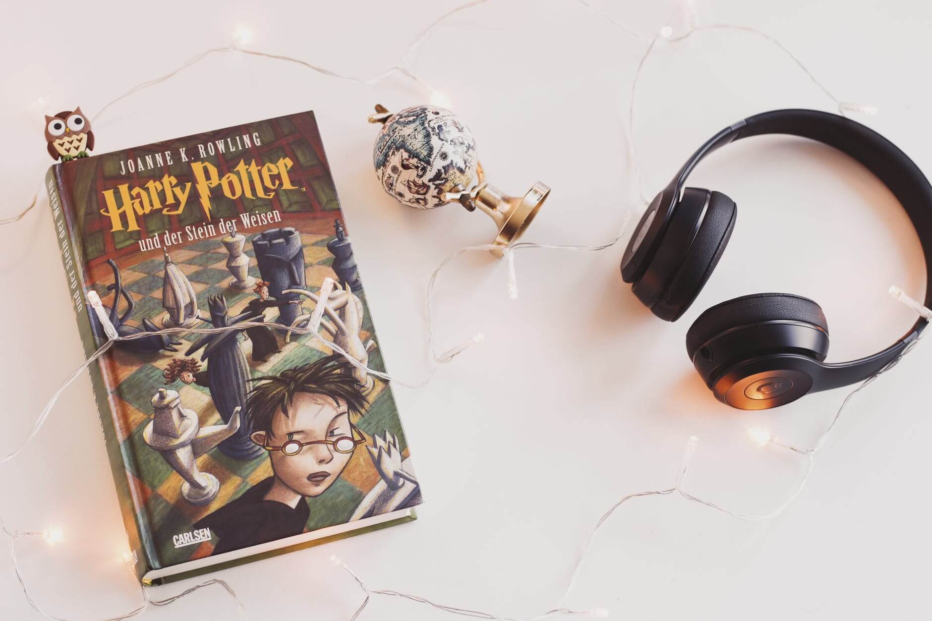 Knjiga Harry Potter i slušalice na bijelom stolu